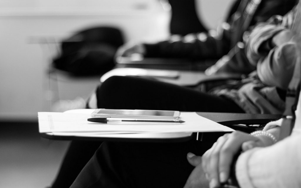 a pen on a desk in a classroom